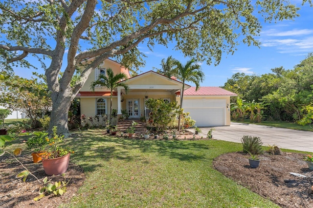 view of front of property featuring a garage, a front yard, and a porch