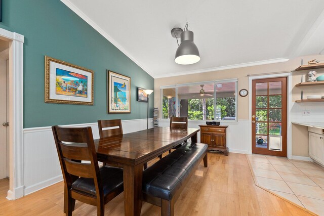 dining space with crown molding, light wood-type flooring, and lofted ceiling