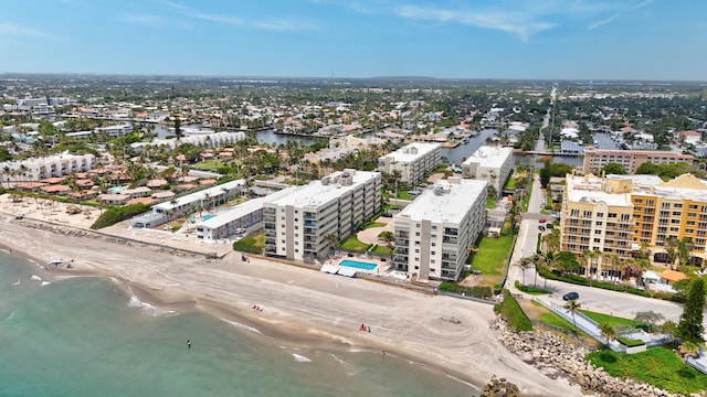 birds eye view of property featuring a beach view and a water view