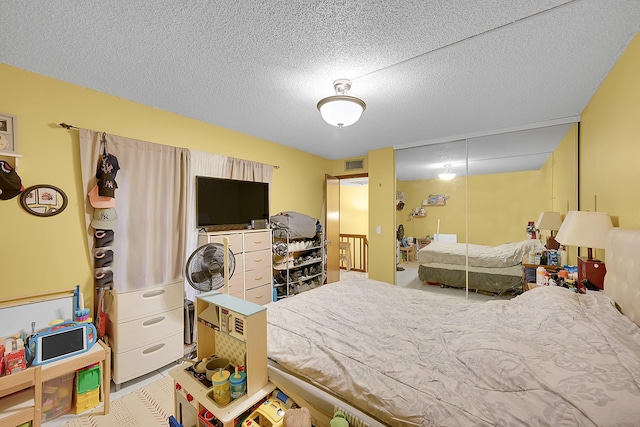 bedroom with a closet, visible vents, and a textured ceiling