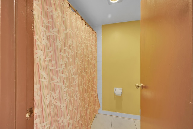 full bathroom featuring shower / tub combo with curtain, baseboards, and tile patterned floors