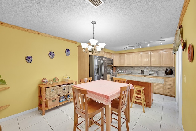 dining area featuring light tile patterned flooring, visible vents, a textured ceiling, and an inviting chandelier