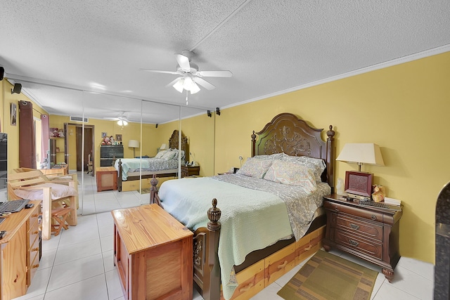 bedroom with crown molding, light tile patterned floors, visible vents, ceiling fan, and a textured ceiling