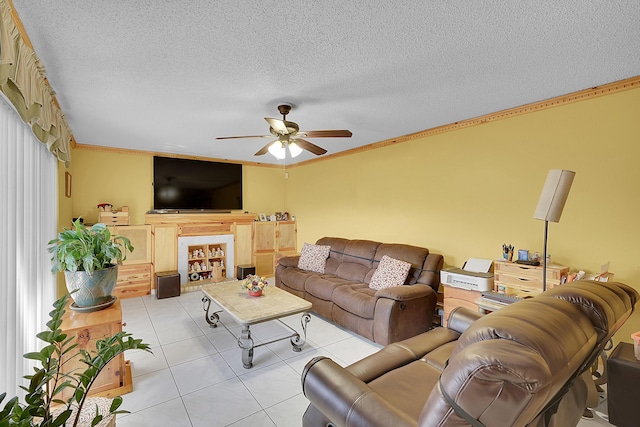 living room with light tile patterned floors, a ceiling fan, a textured ceiling, and ornamental molding