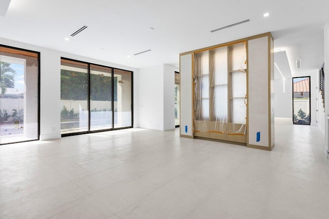 unfurnished room featuring expansive windows and a healthy amount of sunlight