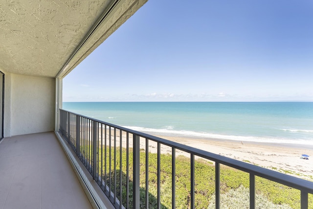 balcony featuring a water view and a view of the beach