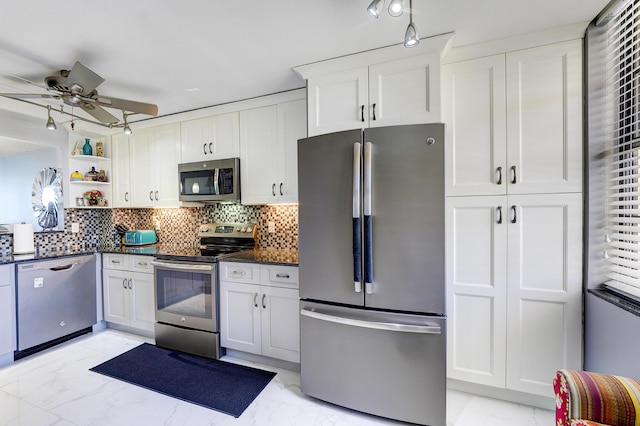 kitchen with white cabinets, ceiling fan, stainless steel appliances, and tasteful backsplash