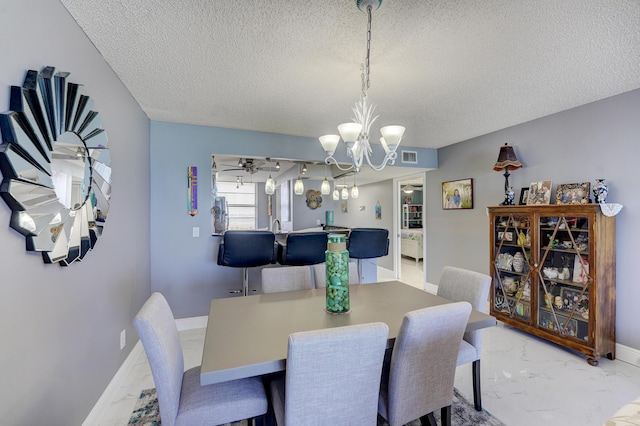 dining room with a textured ceiling and a chandelier