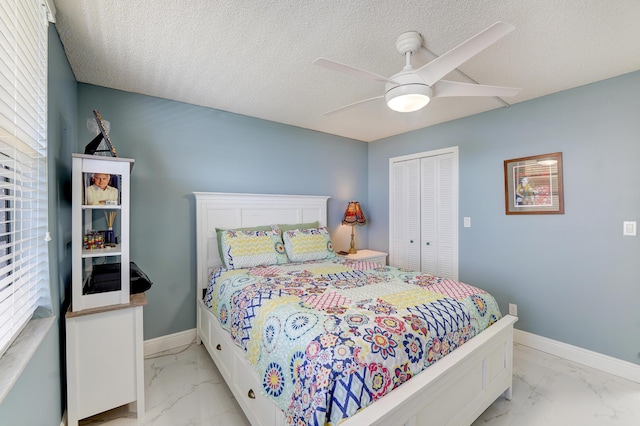 bedroom featuring ceiling fan, a textured ceiling, and a closet