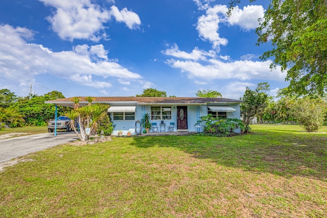 ranch-style home featuring a front yard, a carport, and a porch