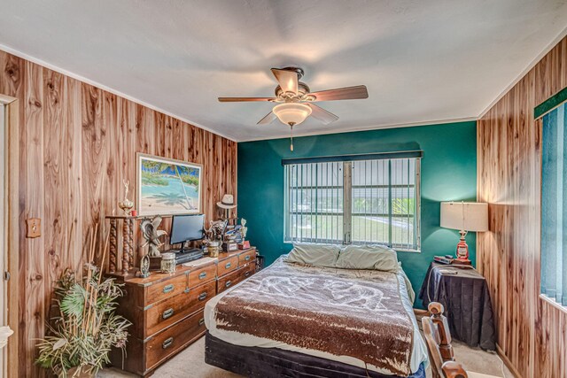 bedroom with light carpet, wooden walls, and ceiling fan