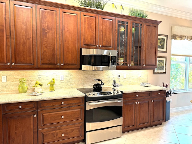 kitchen with stainless steel appliances, light stone countertops, and backsplash