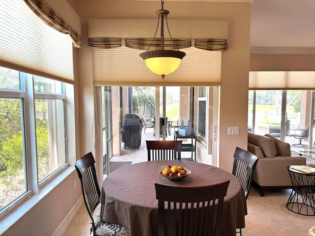 tiled dining room featuring a wealth of natural light and ornamental molding