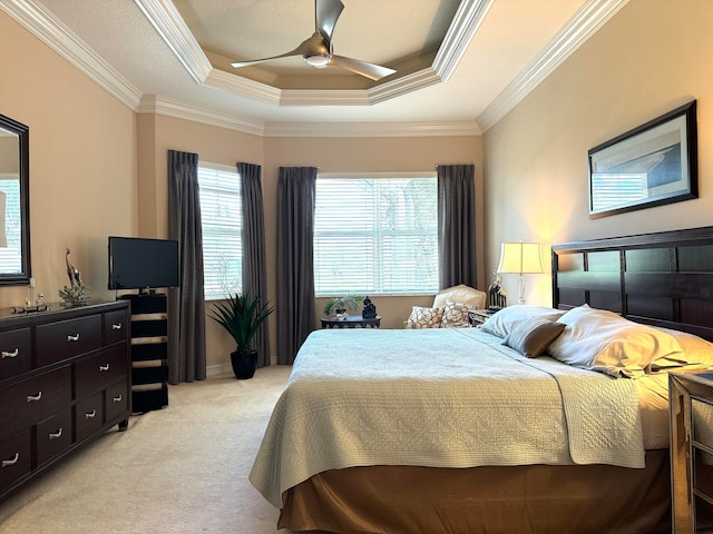 carpeted bedroom featuring ceiling fan, a raised ceiling, and crown molding