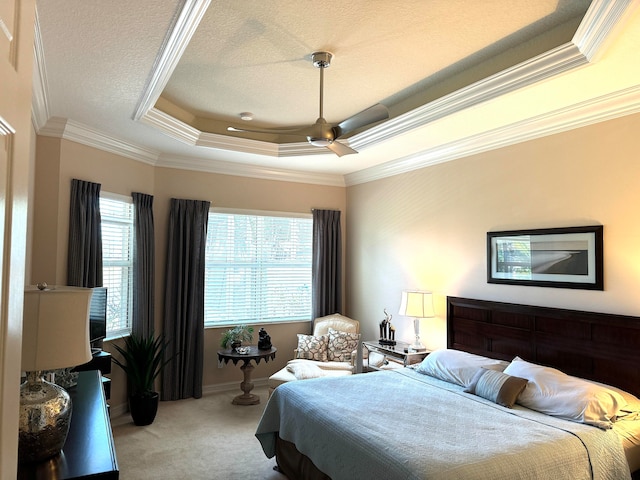 carpeted bedroom featuring ceiling fan, a raised ceiling, and crown molding