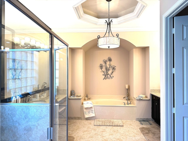 bathroom with a raised ceiling, a bathing tub, ornamental molding, and vanity