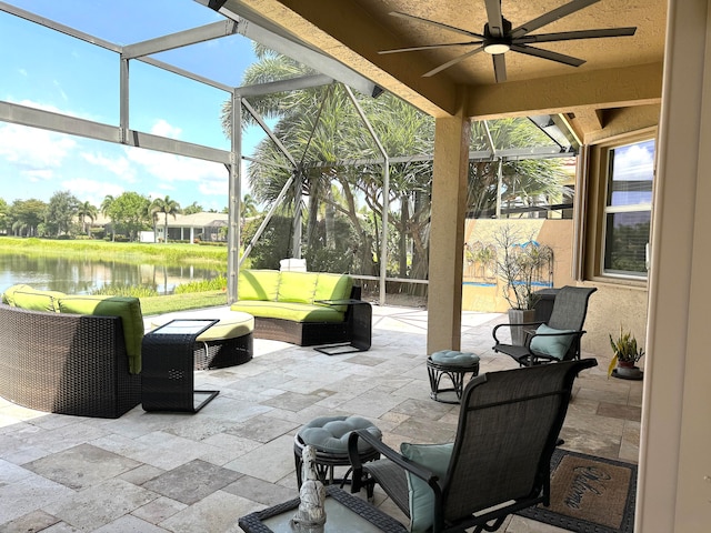 view of terrace featuring a lanai, a water view, an outdoor hangout area, and ceiling fan