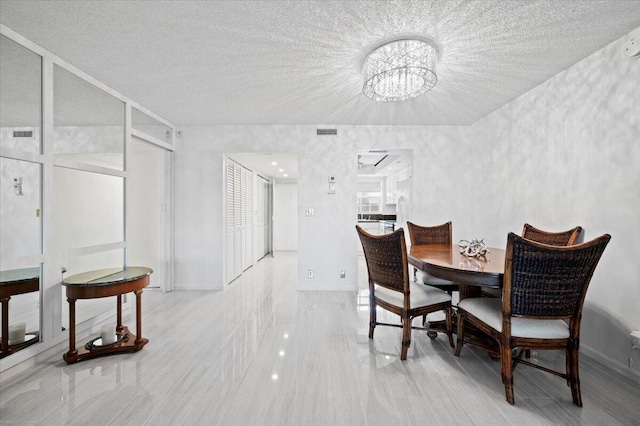 tiled dining space with a textured ceiling