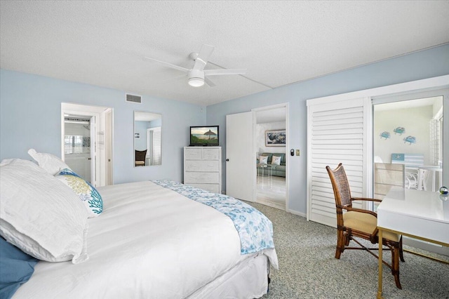 carpeted bedroom featuring ceiling fan and a textured ceiling