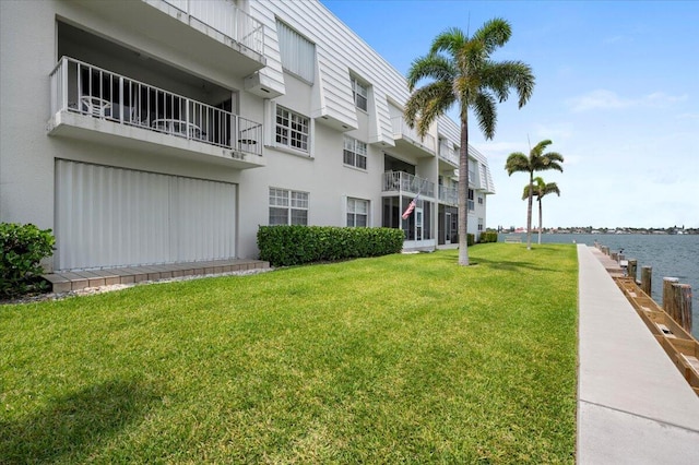 view of property's community with a lawn and a water view