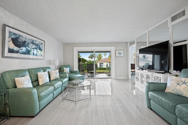 living room with light hardwood / wood-style floors and a textured ceiling