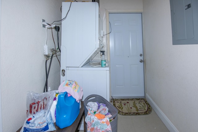 clothes washing area with stacked washer and clothes dryer, tile flooring, and hookup for an electric dryer