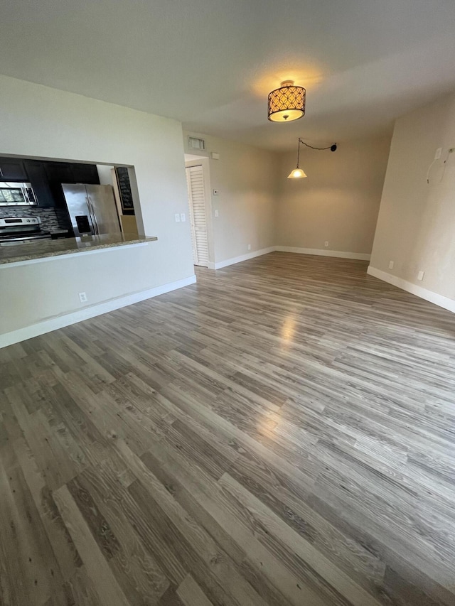 unfurnished living room with dark hardwood / wood-style flooring