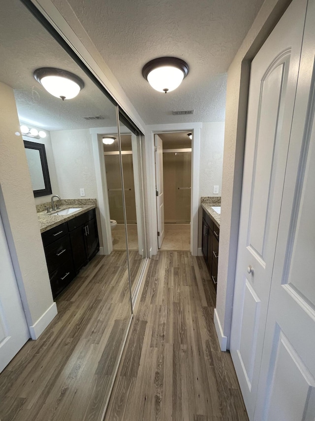 bathroom with vanity, hardwood / wood-style floors, a textured ceiling, and toilet