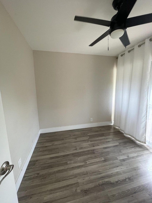 empty room featuring dark wood-type flooring and ceiling fan