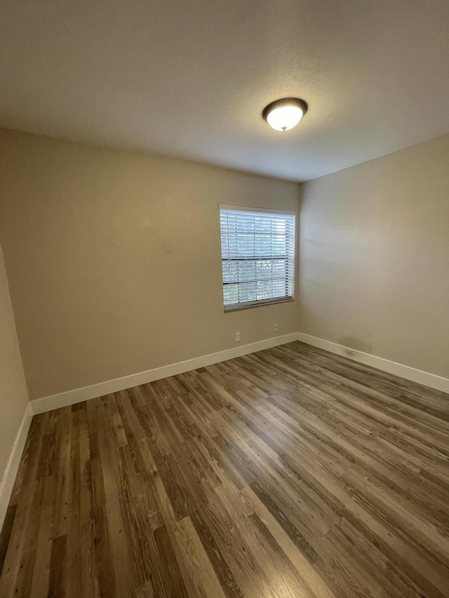 empty room with dark hardwood / wood-style flooring