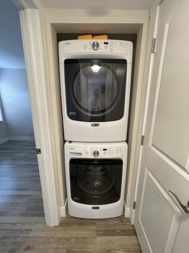 washroom with stacked washer / dryer and dark hardwood / wood-style floors