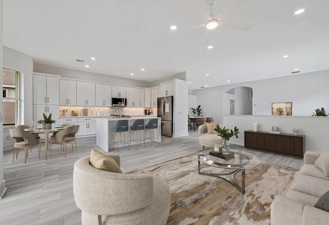 living room with ceiling fan and light wood-type flooring