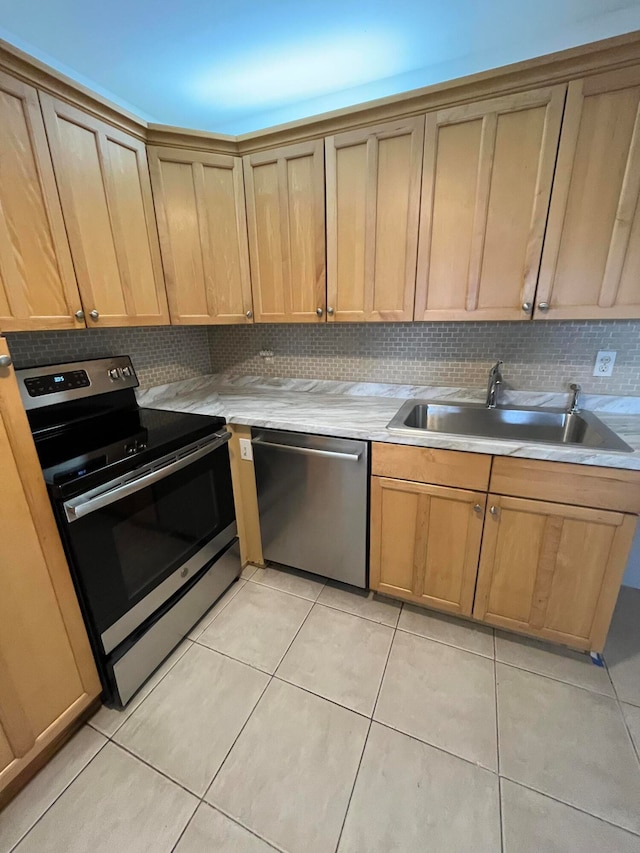 kitchen featuring sink, light tile floors, backsplash, and appliances with stainless steel finishes