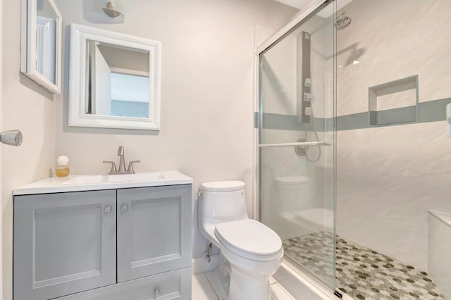 bathroom featuring a shower with door, toilet, and oversized vanity