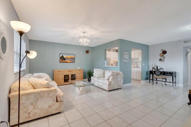 living room with a chandelier and light tile floors