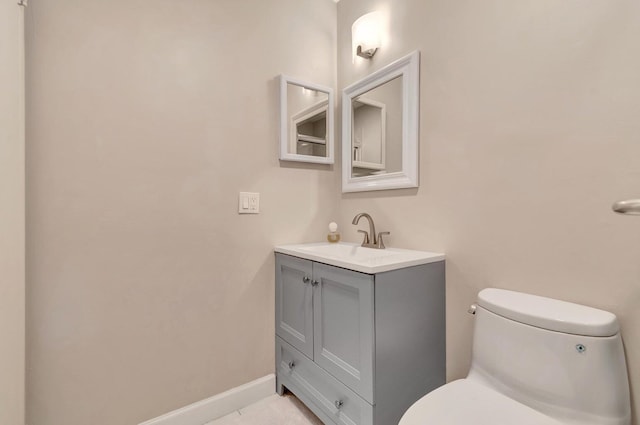 bathroom with tile flooring, toilet, and vanity