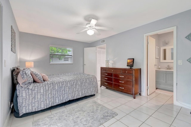 bedroom with light tile flooring, sink, ensuite bathroom, and ceiling fan