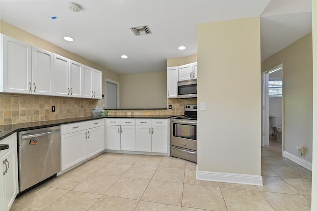 kitchen with light tile patterned floors, decorative backsplash, stainless steel appliances, and white cabinetry