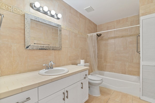 full bathroom with tile patterned floors, vanity, tile walls, toilet, and shower / tub combo with curtain