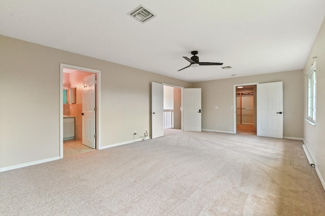 unfurnished bedroom with ensuite bathroom, light colored carpet, ceiling fan, a spacious closet, and a closet