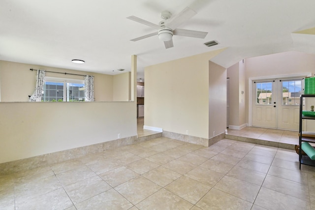 spare room with ceiling fan, light tile patterned floors, and a healthy amount of sunlight