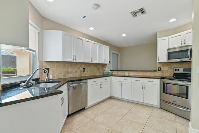 kitchen featuring white cabinets, kitchen peninsula, appliances with stainless steel finishes, and sink