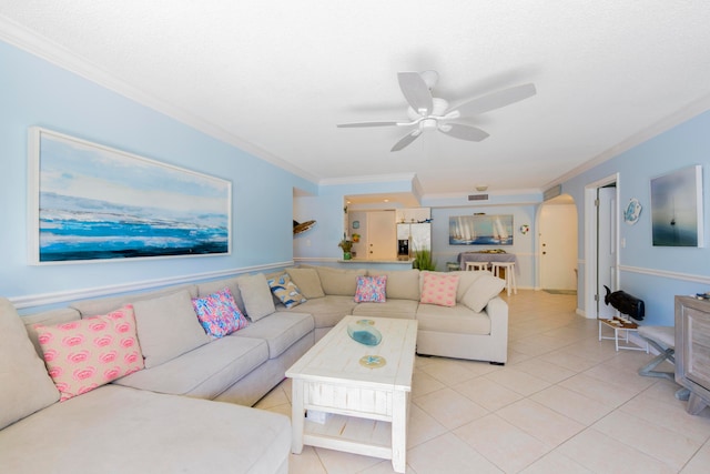 living room featuring ceiling fan, ornamental molding, and light tile floors