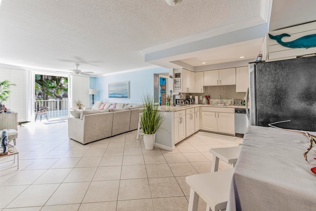 kitchen featuring light tile flooring, ceiling fan, crown molding, white cabinets, and a textured ceiling