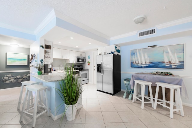 kitchen featuring crown molding, kitchen peninsula, white cabinets, and appliances with stainless steel finishes