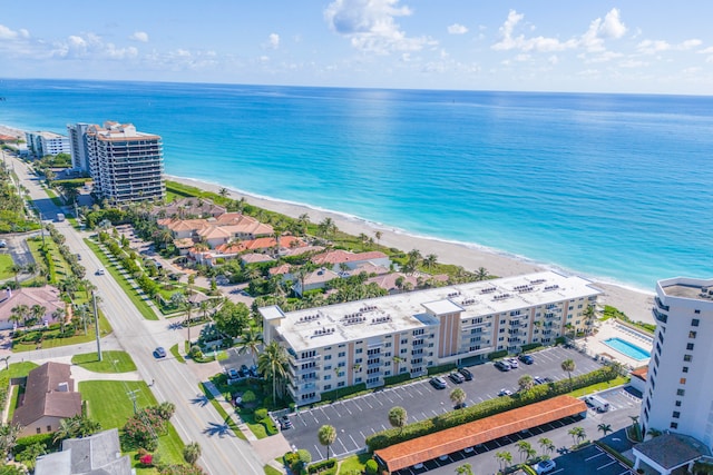 drone / aerial view featuring a beach view and a water view