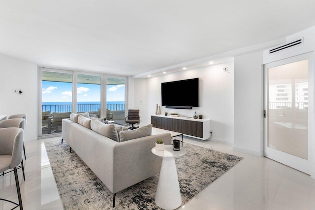 living room featuring floor to ceiling windows, a water view, and light tile flooring