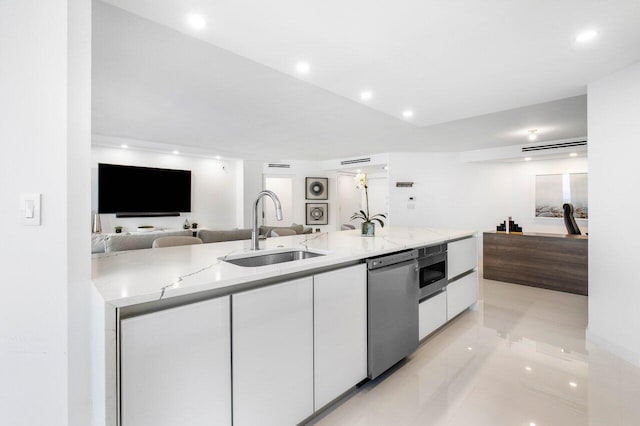 kitchen featuring white cabinetry, stainless steel appliances, light stone counters, sink, and light tile floors