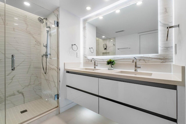 bathroom with tile floors, dual sinks, a shower with shower door, and large vanity