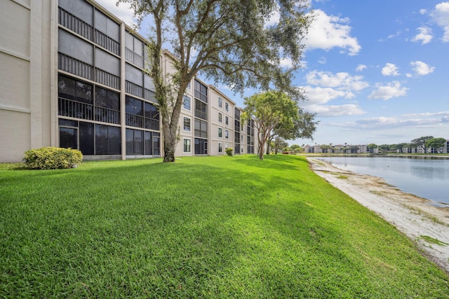 view of property's community with a lawn and a water view